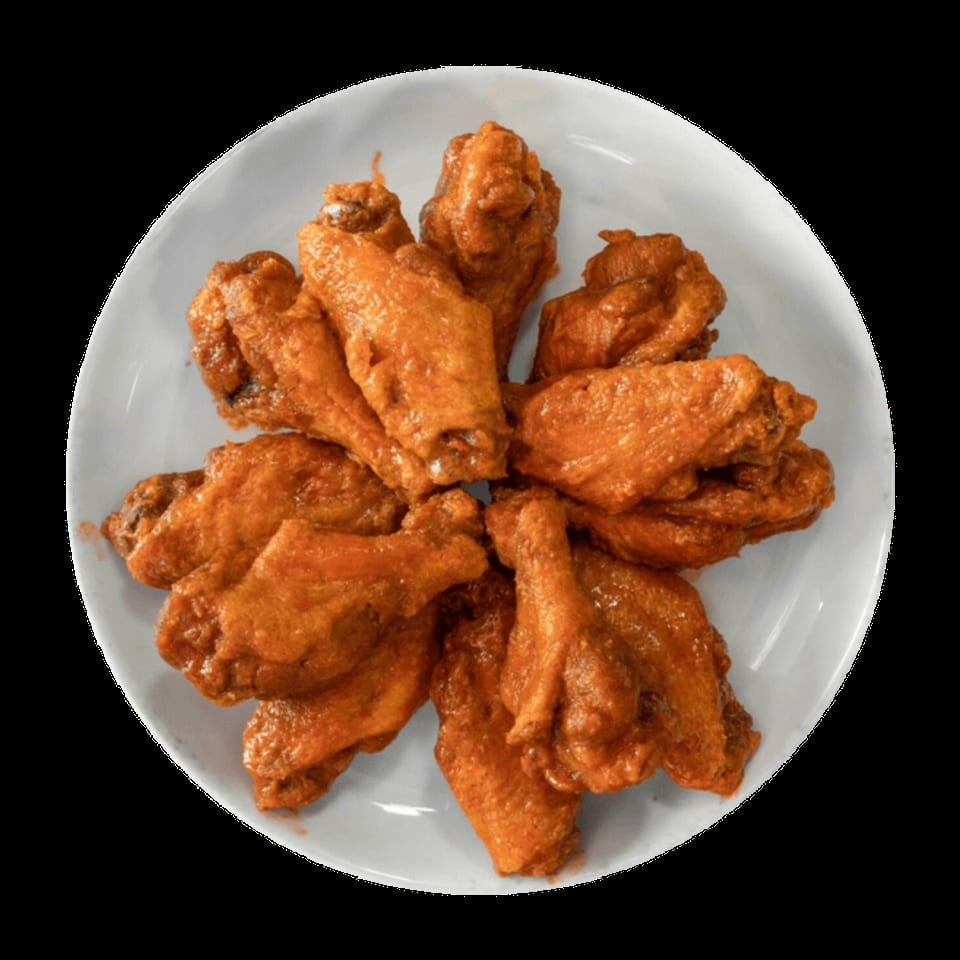 A white plate piled high with golden-brown, saucy chicken wings, viewed from directly above.